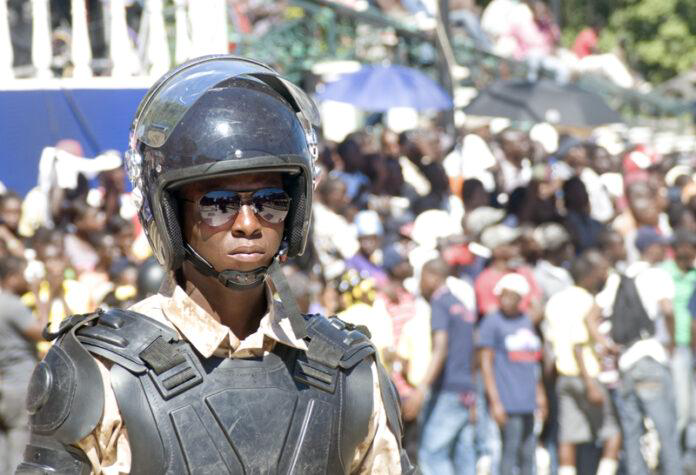 police officer, riot gear, helmet, crowd control, protest, demonstration, security, law enforcement, Haiti