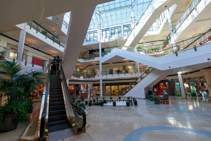 shopping mall, escalator, retail stores, atrium, skylight, multiple floors, indoor shopping center, commercial building